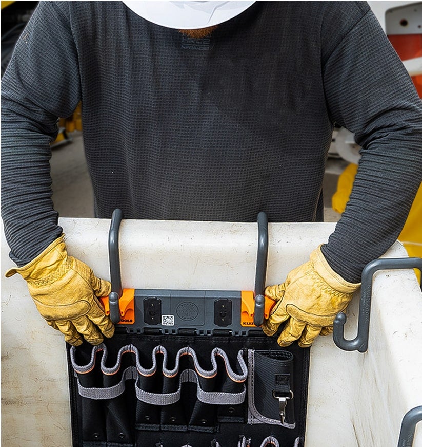 man installing an S-Hook module on a lineman bucket