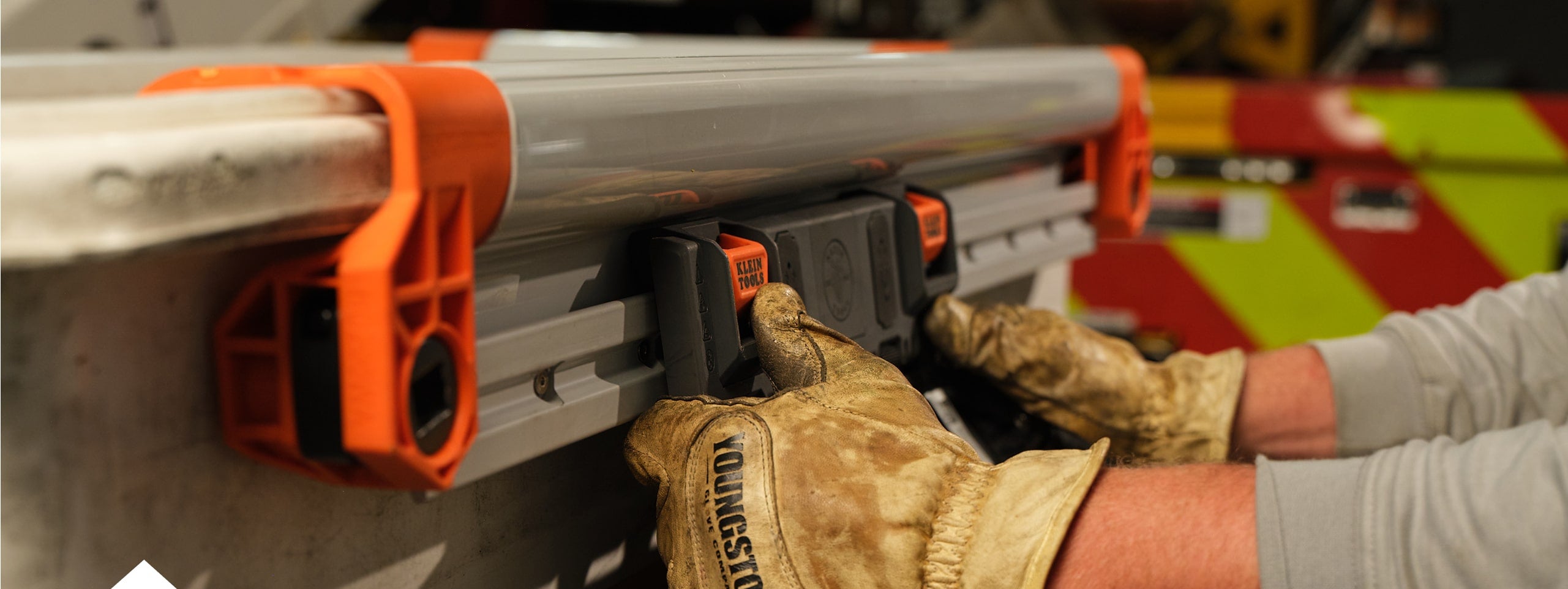 close up photo of a man installing a rail system module on the outside of a rail on a lineman bucket