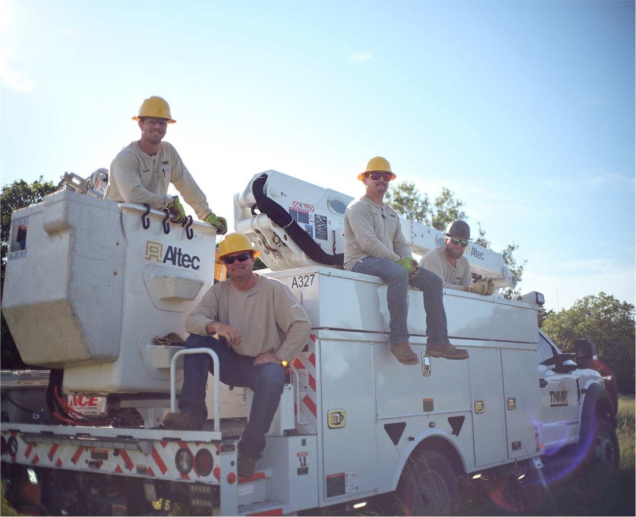 group of lineman sitting on bucket truck