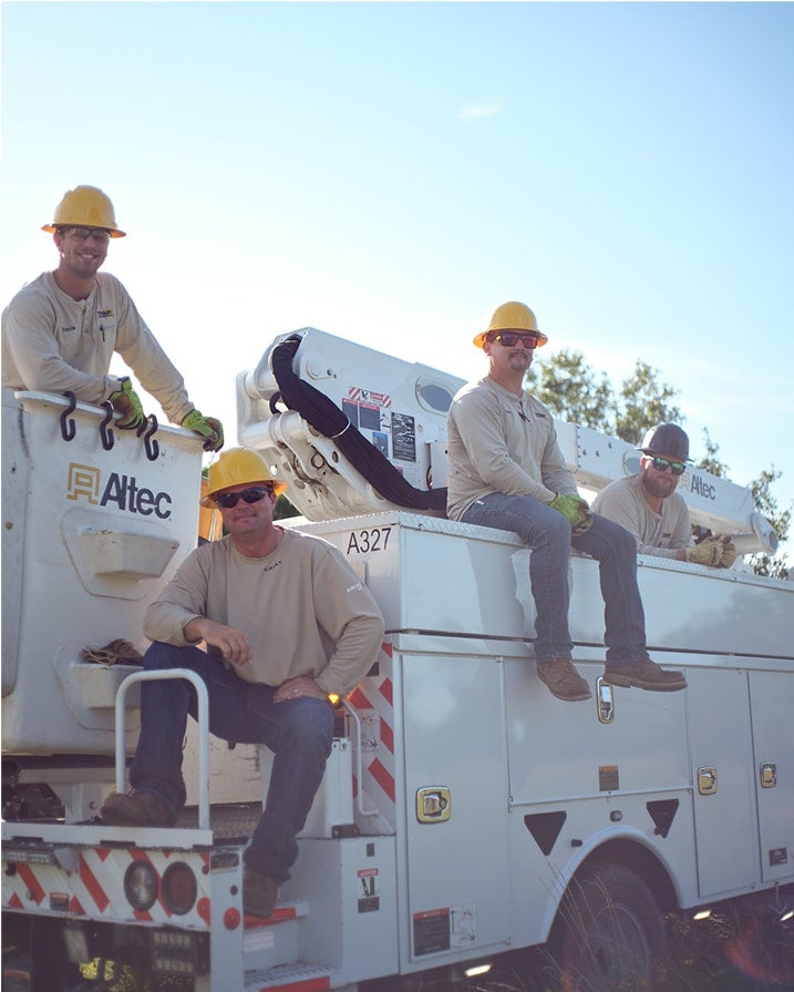 group of lineman sitting on bucket truck