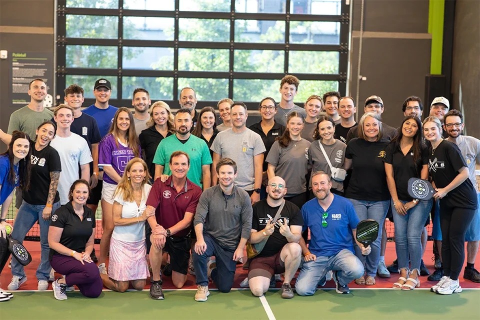 many Klein Tools employees on pickleball court for a large group shot
