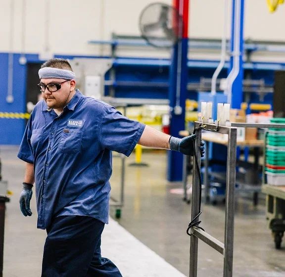 Klein Tools manufacturing employee in a plant pulling a cart
