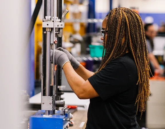 woman working on large machine in manufacturing plant