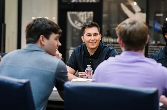 Klein Tools interns sitting at table in conference room