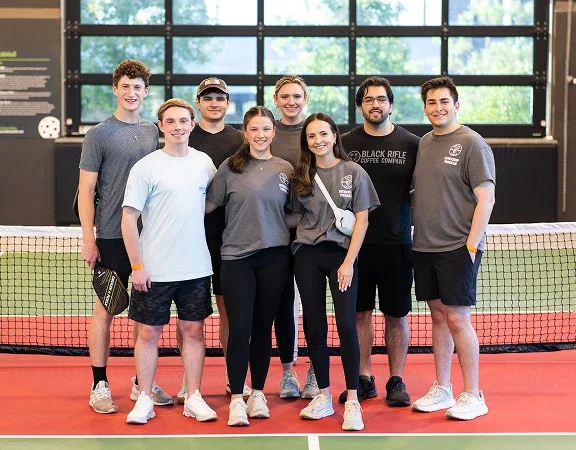 Klein Tools interns standing in front of pickleball net