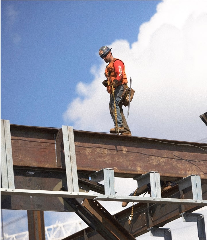 iron worker walking on steel beam