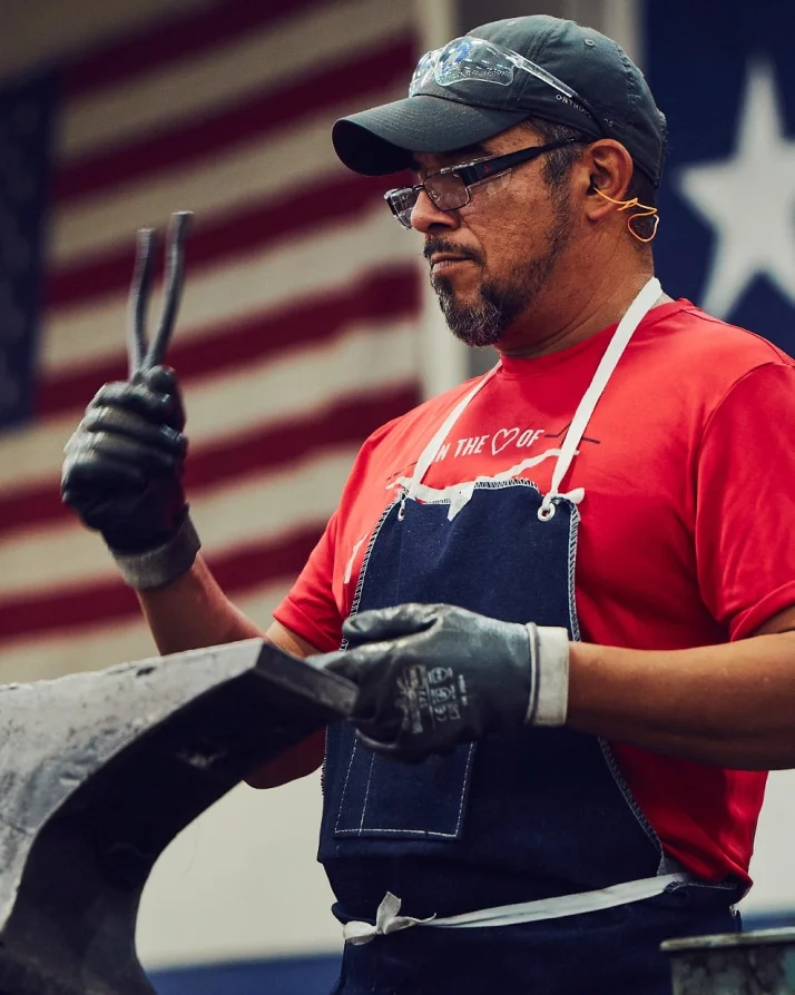 Klein Tools US forging plant worker building pliers with American flag in background