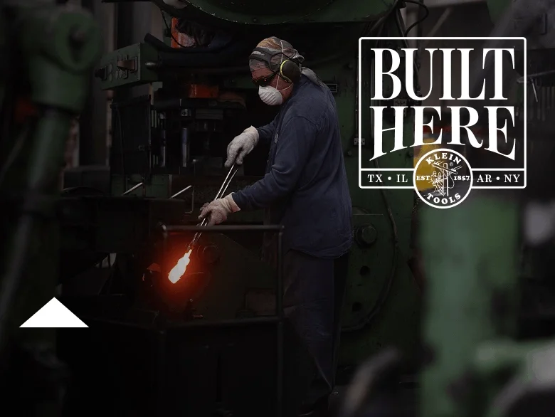 photo of worker holding a pair of pliers in a forge