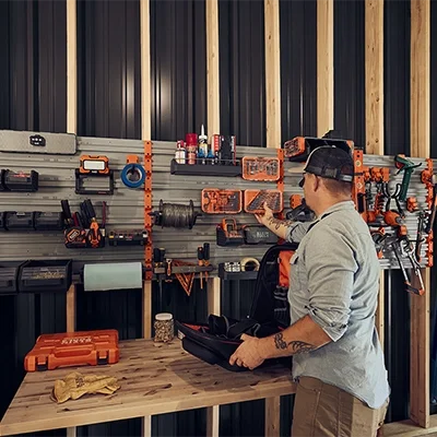 man organizing tools in garage on a MODwall system