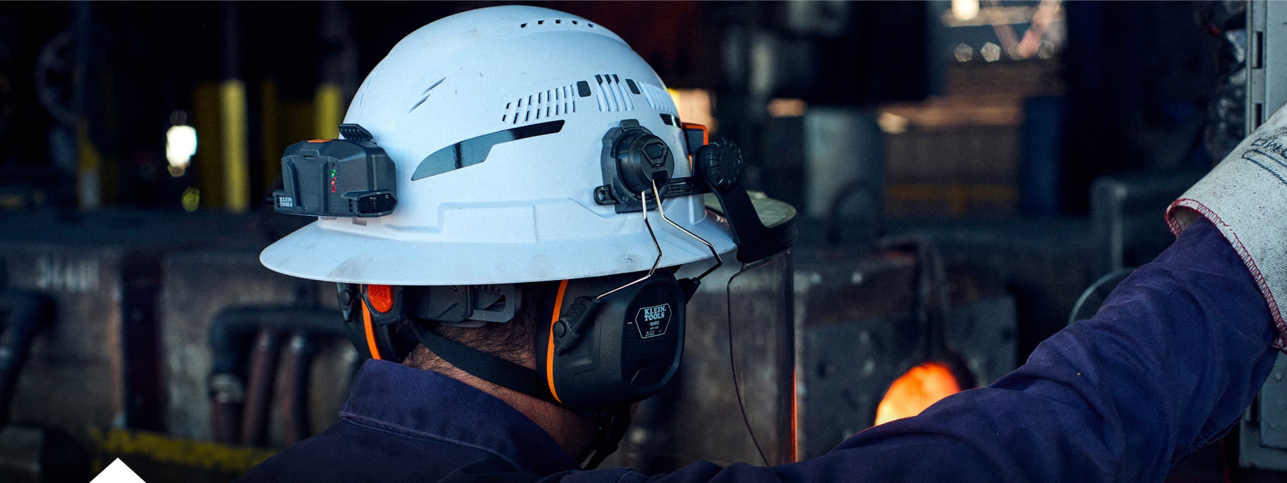 photo of a worker wearing a Klein Tools hart hat with the fan and earmuff accessories